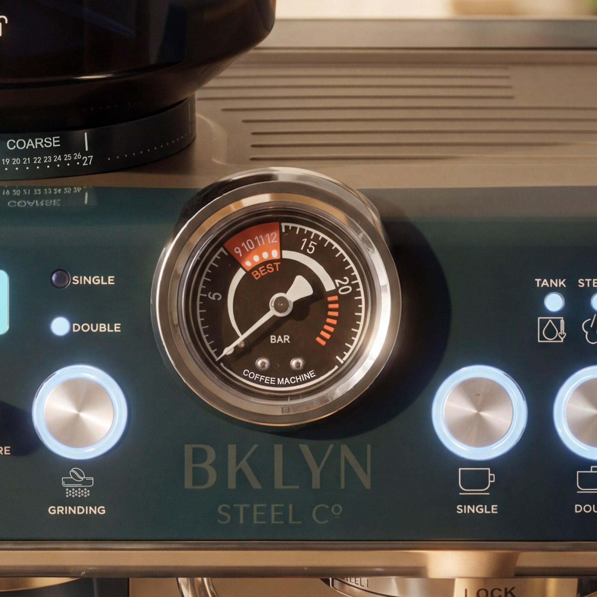 Close-up of a coffee machine control panel with a gauge and 'BKLYN Steel Co' branding.
